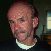 Older man with reddish-brown receding hair and a salt-and-pepper mustache